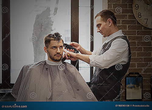 A man getting a haircut at a barbershop - how much should a men's haircut cost
